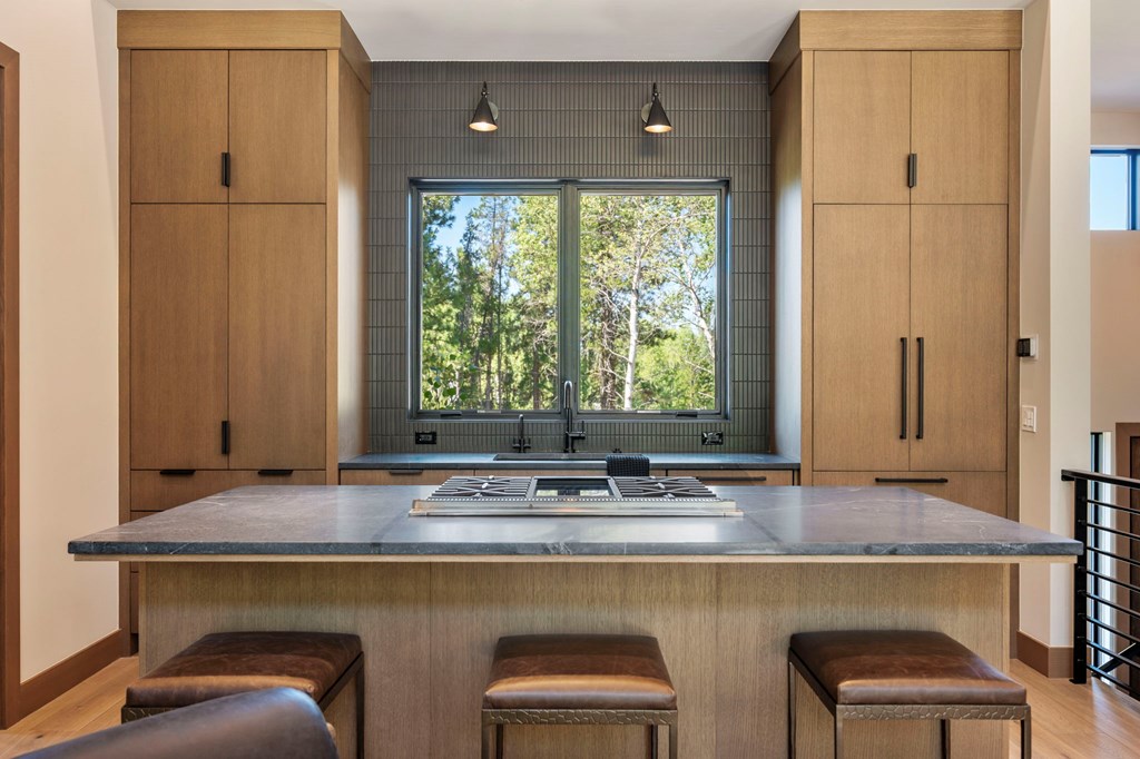 Modern mountain kitchen in McCall, Idaho featuring custom wood cabinetry, soapstone countertops, and a large center island with bar seating — ideal for entertaining in a luxury vacation home or short-term rental property.