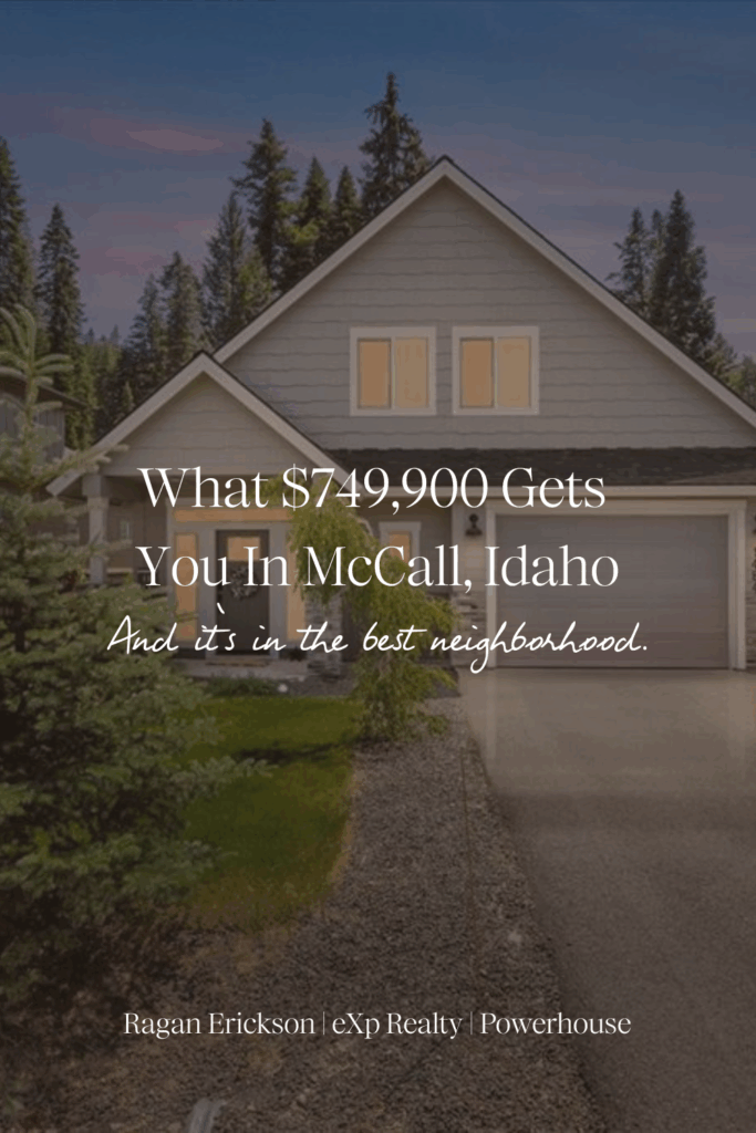 Front exterior view of a modern mountain home for sale at 1484 Dragonfly Loop in McCall, Idaho, featuring gray siding with white trim, a two-car garage, and a neatly landscaped yard surrounded by evergreen trees and forested mountain scenery under a bright blue sky.
