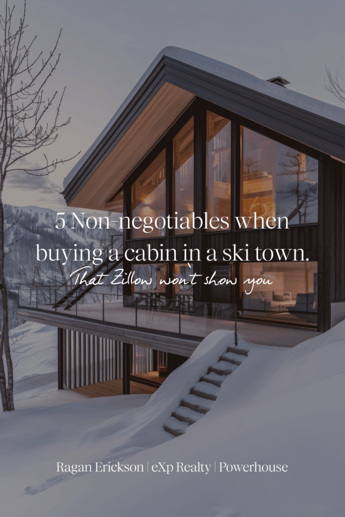 Modern mountain cabin with warm lights glowing through floor-to-ceiling windows, surrounded by deep snow at sunset — perfect visual for an article about buying a cabin in a ski town and understanding what Zillow won’t show you.