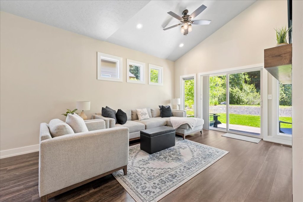 Bright open living room in a McCall, Idaho home with vaulted ceilings, neutral tones, and large windows overlooking the backyard. This McCall real estate property showcases a cozy modern design perfect for mountain living.