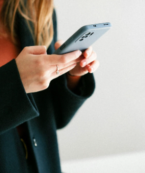 Young woman looks at Facebook from her cell phone