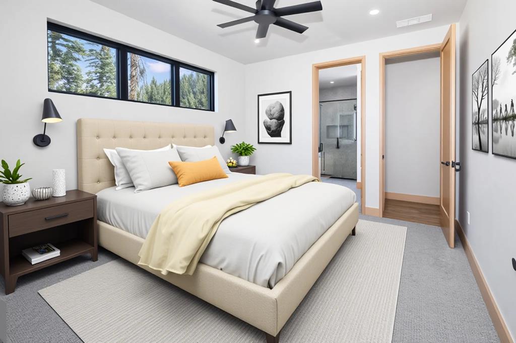 Cozy staged bedroom with upholstered bed, forest views through clerestory windows, and ensuite bathroom access.