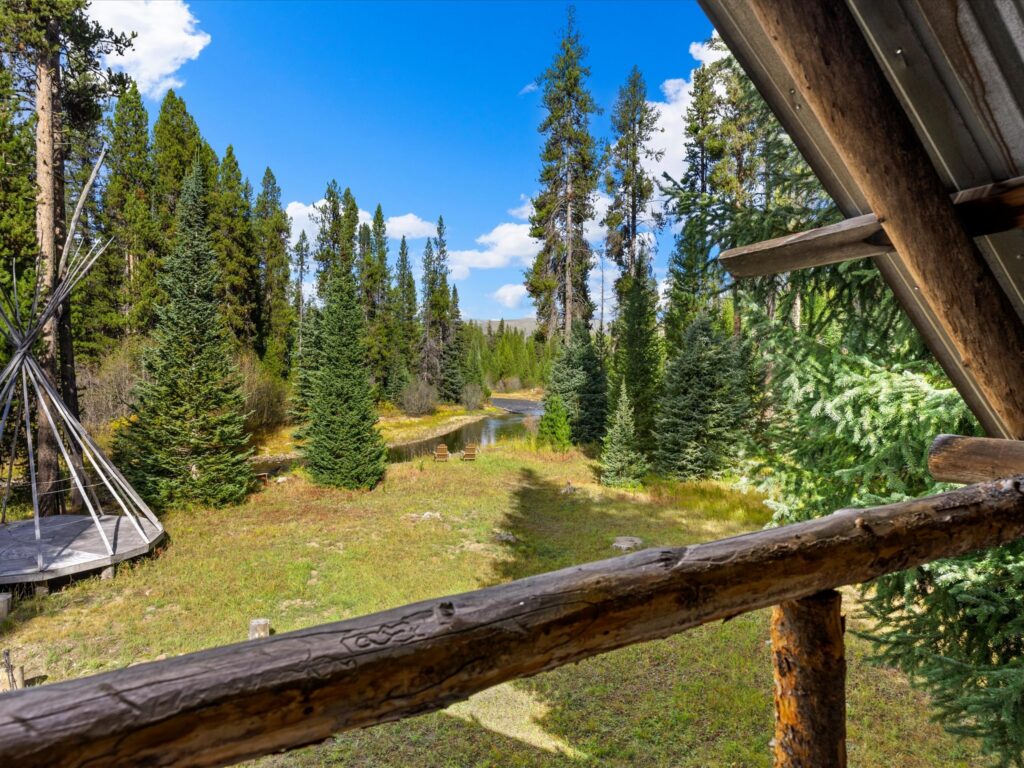 View from the cabin's upper balcony across the meadow to the teepee and the Secesh River