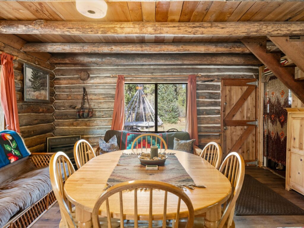 Dining area with a built-in bench and a window looking out to the teepee