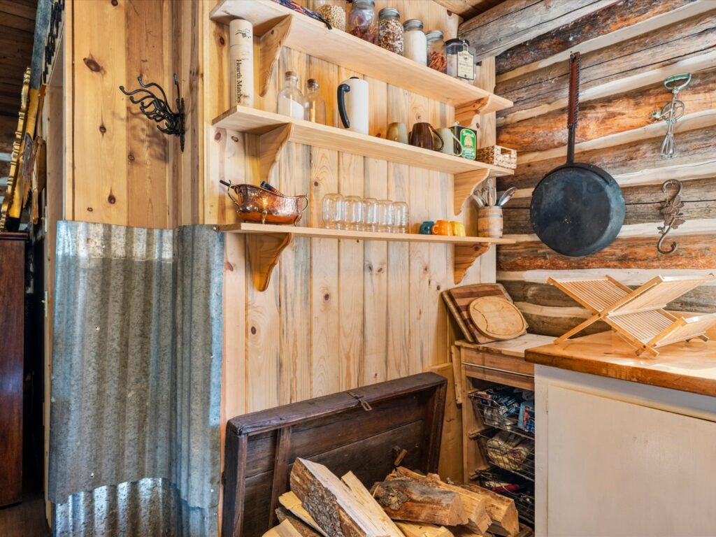 Open pantry shelving and firewood storage beside the kitchen