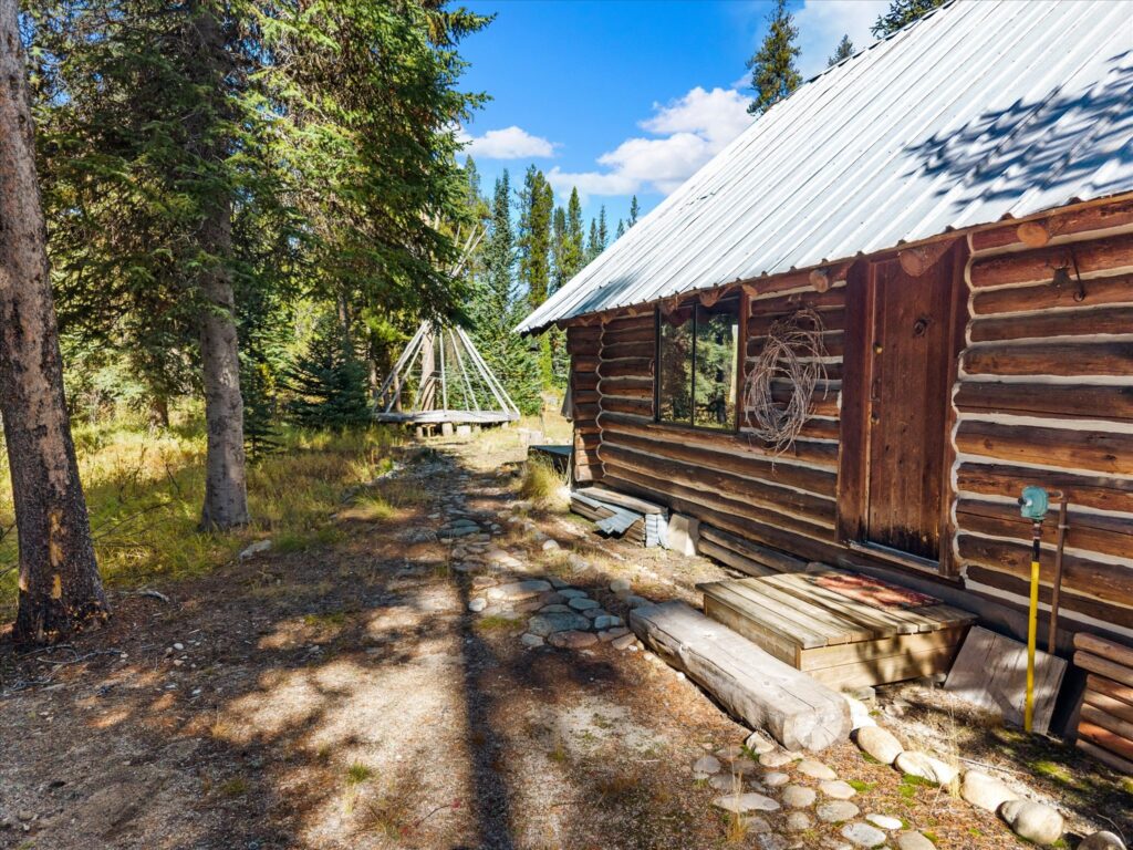 Walkway along the side of the log cabin toward the teepee clearing